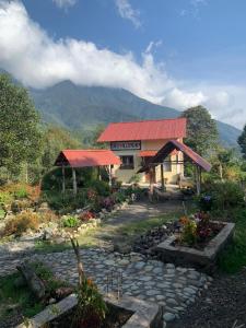 un edificio con techo rojo junto a un jardín en URKU ALLIPACHA FINCA ORGÁNICA CASA DE CAMPO, en Luisa