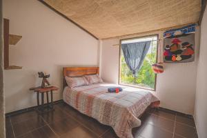 1 dormitorio con cama y ventana en URKU ALLIPACHA FINCA ORGÁNICA CASA DE CAMPO, en Luisa