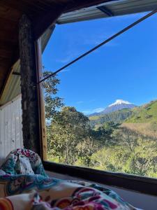 1 dormitorio con ventana y vistas a las montañas en URKU ALLIPACHA FINCA ORGÁNICA CASA DE CAMPO, en Luisa
