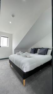 - une chambre dotée d'un grand lit avec des draps blancs et des oreillers bleus dans l'établissement Lovely 2 Bed Apartment by YO ROOM- Leicester City- Free Parking, à Leicester