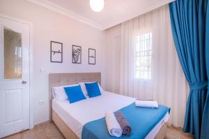 a bedroom with a bed and a blue curtain at Villa Erya 2 in Fethiye +25 photos