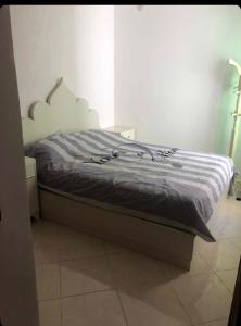 een slaapkamer met een bed met een wit hoofdeinde bij 2 slaapkamers appartement zwembad in Tanger