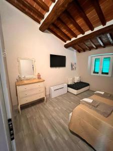 Cette chambre comprend une chambre avec un lit et une télévision. dans l'établissement Chianti chic, à Gaiole in Chianti