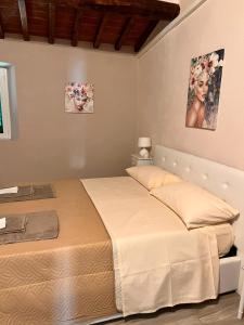 a bed in a bedroom with two pictures on the wall at Chianti chic in Gaiole in Chianti