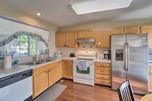 a kitchen with wooden cabinets and a stainless steel refrigerator at Family Home with Fenced Yard 15 Mi to Denver! in Broomfield