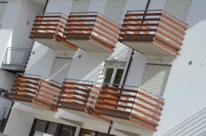an external view of a building with wooden balconies at Elaia Garden Hotel in Sperlonga