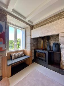 sala de estar con chimenea y ventana en The Tailor's Garden, en Santiago de Compostela