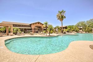 a swimming pool in a resort with chairs and palm trees at Comfy Scottsdale Condo with Resort Amenities! in Scottsdale