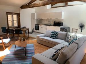 a living room with a couch and a table and a kitchen at Appartements au Château Ars in Ars-sur-Formans