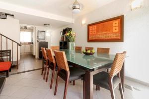 a dining room with a glass table and chairs at Relaxing Village, Acapulco Diamante, Rooftop in Acapulco