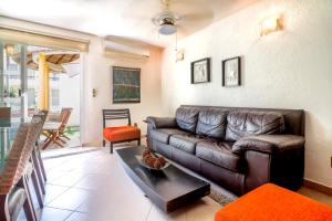 a living room with a brown leather couch at Relaxing Village, Acapulco Diamante, Rooftop in Acapulco
