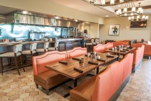 a restaurant with orange chairs and tables and a bar at The Bear's Den Resort Orlando in Kissimmee