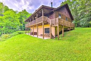 une grande maison avec une terrasse sur une pelouse dans l'établissement Slaty Fork Escape with Mountain View and Hot Tub!, à Slaty Fork