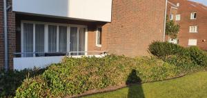 eine Hecke vor einem Backsteingebäude in der Unterkunft Ferienidyll Langeoog in Langeoog
