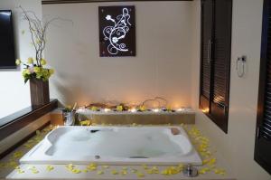 wanna z żółtymi kwiatami wokół niej w łazience w obiekcie Auto Hotel Deluxe w mieście El Alcanfor