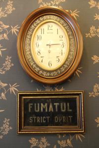 a clock hanging on a wall next to a sign at Hotel Style BESSARABIA in Kiliya