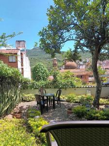 a patio with a table and chairs and a tree at Caracol Casa Turística in San Gil +15 photos