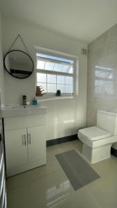 a bathroom with a toilet and a sink and a window at Lovely 2 Bed Apartment by YO ROOM- Leicester City- Free Parking in Leicester