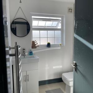 a bathroom with a toilet and a window at Lovely 2 Bed Apartment by YO ROOM- Leicester City- Free Parking in Leicester