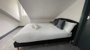 Lovely 2 Bed Apartment by YO ROOM- Leicester City- Free Parking في ليستر: غرفة نوم بسرير ابيض كبير مع مخدات