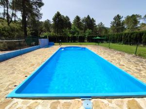 a large blue swimming pool in the middle of a yard at Casa Esmeralda en ZAFIRO LAGUNAZO Parque Natural Rio Mundo Riopar in Riópar