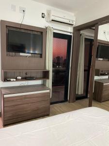 a room with a tv and a bed with a bed gmaxwell gmaxwell gmaxwell at 1810 - Flat para temporada em Goiania-proximo ao Parque Areião in Goiânia