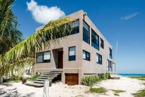 a building on the beach with a palm tree at Casa Gonza Holbox in Holbox Island