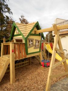 une aire de jeux avec une cabane et un toboggan dans l'établissement Tourist farm Pri Andrejevih, à Narin