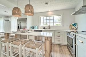 a white kitchen with a large island with bar stools at Cherokee Lake Home with Private Dock and Patio! in Bean Station