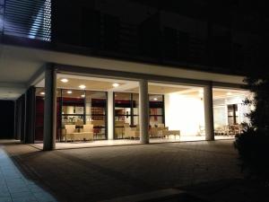 a building with glass doors and tables and chairs at Elaia Garden Hotel in Sperlonga