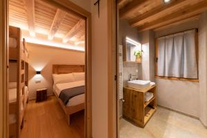 1 dormitorio con 1 cama y lavamanos en una habitación en Foresteria Spluga, en Campodolcino