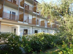 an apartment building with balconies and trees at Elaia Garden Hotel in Sperlonga