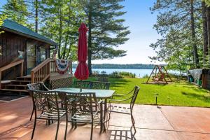 a table and chairs with an umbrella on a deck at Catfish Cottage A in Eagle River