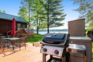 una parrilla en un patio con una mesa y una casa en Catfish Cottage B en Eagle River