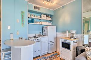 - une cuisine avec des appareils blancs et un mur bleu dans l'établissement Beachside Corpus Christi Condo with Amenities!, à Corpus Christi