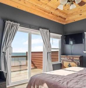 une chambre avec un lit et une vue sur l'océan dans l'établissement Stunning Beachfront 3 Bedroom Home, CoralMoonBeach, à Bolivar Peninsula