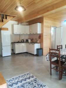 a kitchen with white appliances and a wooden ceiling at Little house Katia Mestia in Mestia