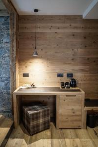 a kitchen with a wooden wall with a counter at Sci Sport rooms & suites in Bormio