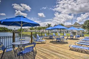 a deck with chairs and tables and blue umbrellas at Kissimmee Condo Community Perks, 10 Mi to Disney! in Kissimmee
