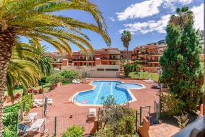 an apartment with a swimming pool and palm trees at Starfish playa in Los Cancajos