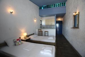 1 dormitorio con 2 camas y balcón en St George Studios & Apartments, en Batsi