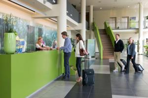 a group of people standing in a lobby with luggage at ATLANTIC Hotel Galopprennbahn in Bremen