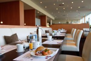 a restaurant with a plate of food on a table at Atlantic Hotel Galopprennbahn in Bremen