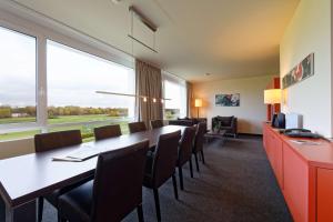 a conference room with a long table and chairs at ATLANTIC Hotel Galopprennbahn in Bremen