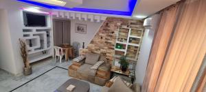 salon z kanapą i ceglaną ścianą w obiekcie L'Andalousia w mieście Arjana