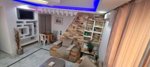 a living room with a couch and a brick wall at L'Andalousia in Ariana