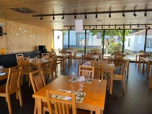 a restaurant with wooden tables and chairs and windows at Solar Do Conde in Capelas