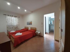 a bedroom with a red bed and a bathroom at Villa GenVì - casa vacanza in Polignano a Mare