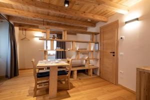 a dining room with a wooden table and chairs at Foresteria Spluga in Campodolcino