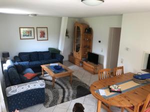 ein Wohnzimmer mit einer blauen Couch und einem Tisch in der Unterkunft Ferienwohnung am Rohrbacherhof Sabine Rück in Barackenhöfe
